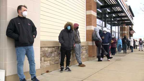 People wait in line to receive a COVID-19 test at  PhysicianOne Urgent Care in Westwood, Massachusetts, on Dec. 26, 2021.