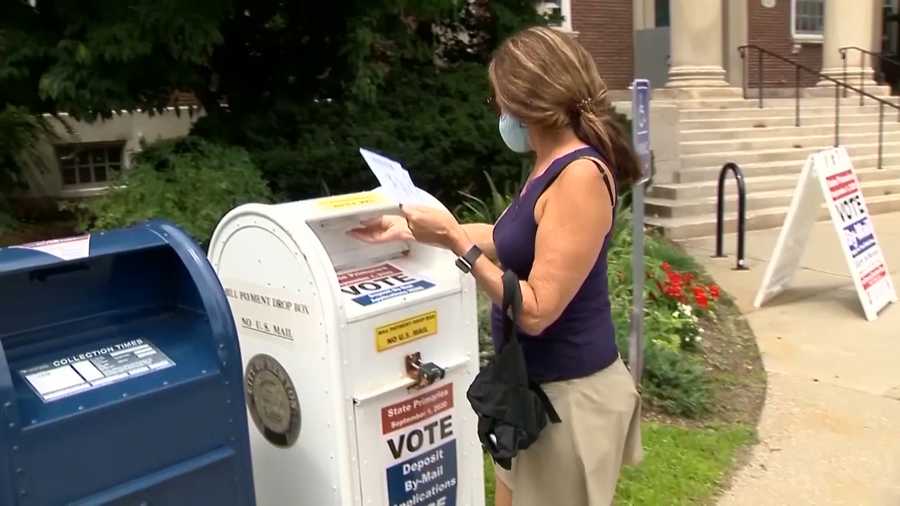 A Massachusetts voter drops off a mail-in ballot in Newton.